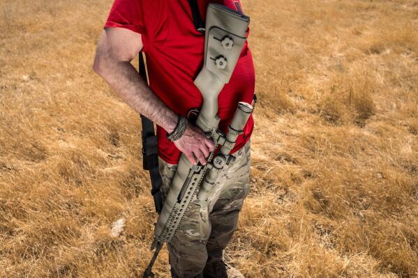 Firearms instructor Michael Palombo holds a Springfield Armory M25 rifle during field testing to measure radio frequency identification signal range in Hickman, Calif., on Sunday, June 6, 2021. Palombo inserted an RFID tag into the rifle for the test. (AP Photo/Noah Berger)