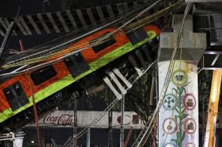 FILE- In this May 4, 2021 file photo, Mexico City's subway cars lay at an angle after a section of Line 12 of the subway collapsed in Mexico City. Mexico City´s prosecutor´s office concluded Thursday, Oct. 14, 2021, that the accident was due to mistakes made during the construction of the metro line and that it will prosecute those involved in the crash. (AP Photo/Marco Ugarte, File)