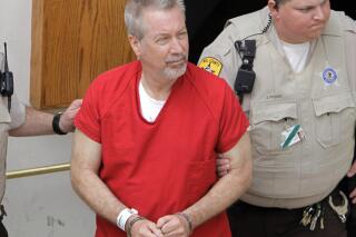 FILE - In this May 8, 2009, file photo, former Bolingbrook, Ill., police Sgt. Drew Peterson leaves the Will County Courthouse in Joliet, Ill., after his arraignment on charges of first-degree murder in the 2004 death of his former wife Kathleen Savio. Peterson is getting another chance to argue that his murder conviction in the death of his third wife should be thrown out. A Will County judge has scheduled a Jan. 21, 2022 hearing on Peterson's motion that the conviction should be tossed because his lead attorney did not provide effective counsel and prosecutors acted improperly. (AP Photo/M. Spencer Green, File)