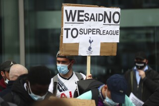 Tottenham fans stage a protest against the Board over the planned creation of a European Super League, outside the Tottenham Hotspur Stadium in London, England, Wednesday, April 21, 2021. Over two fraught days in April 2021 a newly-formed “Super League” threatened to change the face of European soccer by creating an elite tournament that would effectively be a closed shop for 15 of the richest clubs in the world. It collapsed amid a furious backlash from fans and on Tuesday, Nov. 7, 2023, King Charles announced a U.K. government bill that would have the power to block teams from attempting to join a breakaway league in the future. (Clive Rose/Pool via AP, File)