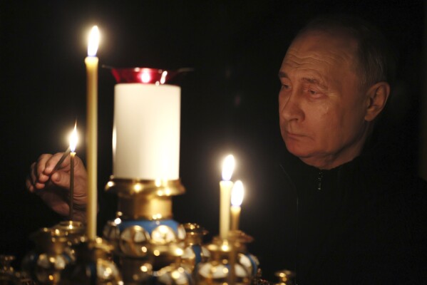 FILE - Russian President Vladimir Putin lights a candle to commemorate victims of an attack on the Crocus City Hall concert venue, on the day of national mourning, in Russia, Sunday, March 24, 2024. The March 22 attack that killed over 140 people marked a major failure of Russian security agencies. (Mikhail Metzel, Sputnik, Kremlin Pool Photo via AP, File)