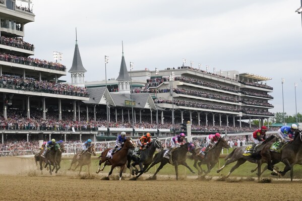 FILE - Javier Castellano, atop Mage, third from left, is seen with others behind the pack as they make the first turn while competing in the 149th running of the Kentucky Derby horse race at Churchill Downs Saturday, May 6, 2023, in Louisville, Ky. Horse racing's federally created oversight panel found no single cause of death among 12 horses at Churchill Downs this spring, but recommends further action and analysis to mitigate risk at the home of the Kentucky Derby, according to a report released Tuesday, Sept. 12. (AP Photo/Julio Cortez, File)