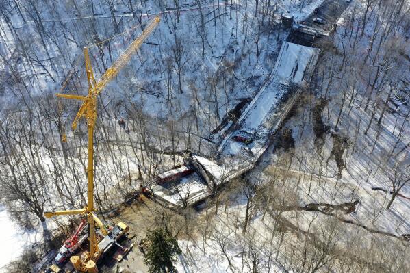 FILE - A crane is in place as part of clean up efforts at the Fern Hollow Bridge in Pittsburgh that collapsed, Jan. 28, 2022. Investigators looking into the collapse of the bridge nearly one year ago are looking closely at damage to the legs of the structure. A report issued Thursday, Jan. 26, 2023 by the National Transportation Safety Board about the failure of the Fern Hollow Bridge says its engineers are examining “multiple fractures” found on the bridge’s legs. (AP Photo/Gene J. Puskar, file)