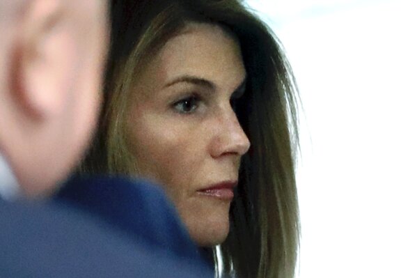 FILE - In this Aug. 27, 2019, file photo, Lori Loughlin enters through the back door at federal court in Boston for a hearing in a nationwide college admissions bribery scandal. Federal prosecutors in a legal document filed late Wednesday, April 8, 2020, denied allegations that investigators deliberately withheld and fabricated evidence to entrap actress Loughlin, her fashion designer husband Mossimo Giannulli and other prominent parents charged with cheating the college admissions process. (AP Photo/Steven Senne, File)