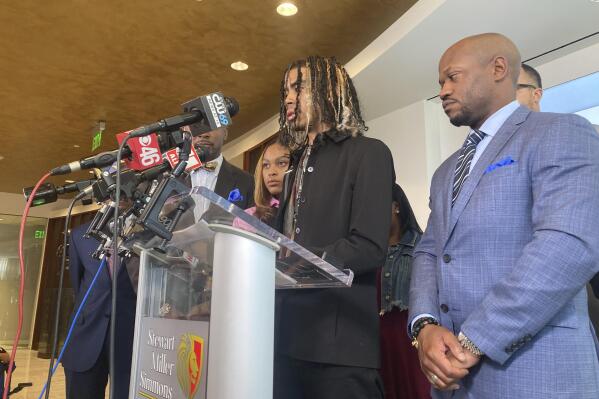 Messiah Young speaks during a news conference accompanied by attorney L. Chris Stewart, right, who represents plaintiff Taniyah Pilgrim, background center, in Atlanta on Thursday, June 17, 2021. Young and Pilgrim were pulled from their car on May 30, 2020 by Atlanta police and are suing the city and officers for excessive force. Atlanta police had no justification for pulling the two students from their car and hitting them with stun guns while they were stuck in traffic caused by protests over George Floyd's death, the lawsuit announced Thursday claims. (AP Photo/Sudhin Thanawala)