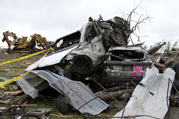 Damaged cars are piled up next to a road after a tornado in Greenfield, Iowa, Tuesday, May 21, 2024.  (AP Photo/Charlie Neighborgal)