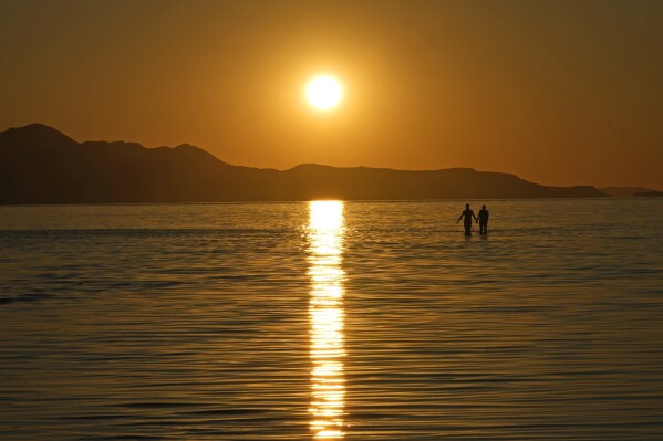 The sun sets on the Great Salt Lake on June 15, 2023, near Magna, Utah. Thanks to an abnormally wet winter that has raised the lake 6 feet from last November's historic low, sailboats and activities are back. (AP Photo/Rick Bowmer)