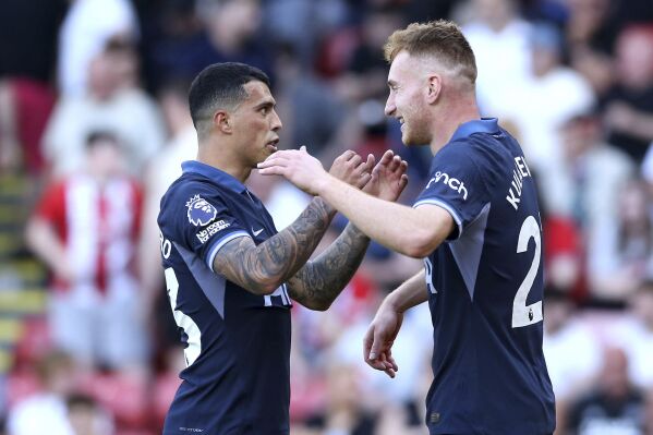Tottenham Hotspur's Dejan Kulusevski, right, celebrates scoring their side's third goal of the game with team-mate Pedro Porro during the Premier League match between Sheffield and Tottenham Hotspur at Bramall Lane, Sheffield., Sunday May 19, 2024. (Barrington Coombs/PA via AP)