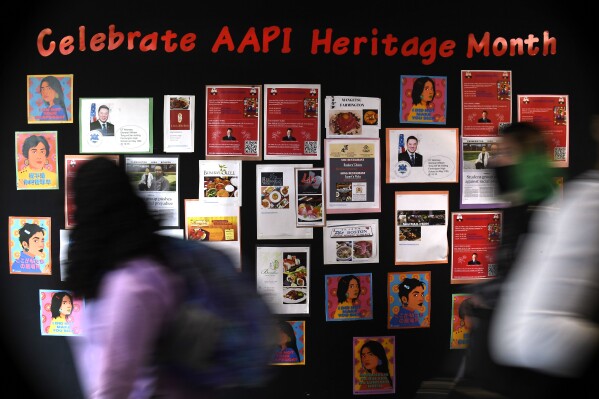 Students walk past a display for Asian Pacific American Heritage Month at Farmington High School in Farmington, Conn., May 10, 2021. (AP Photo/Jessica Hill, File)