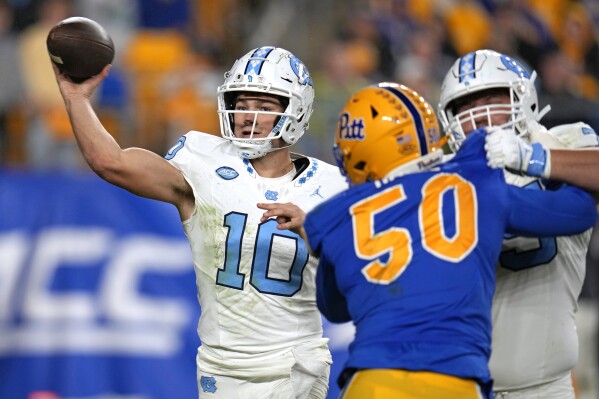 North Carolina quarterback Drake Maye (10) looks to throw a pass under pressure from Pittsburgh defensive lineman Dayon Hayes (50) during the first half of an NCAA college football game in Pittsburgh, Saturday, Sept. 23, 2023. (AP Photo/Gene J. Puskar)