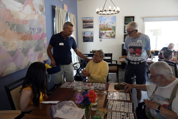 Stonewall Gardens employee Brian Trout, second from left, leads a game of Bingo with residents of the LGBTQ+ assisted living facility, Tuesday, Aug. 15, 2023, in Palm Springs, Calif. (AP Photo/Marcio Jose Sanchez)