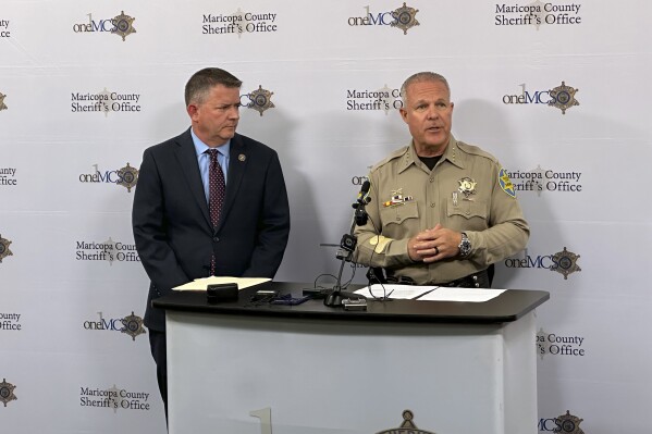  Maricopa County Supervisor Bill Gates, left, and Sheriff Russ Skinner speak Tuesday, June 25, 2024,  during a news conference about a tabulator security fob theft from the elections office in Phoenix. Authorities are investigating whether a 27-year-old temporary election worker had political motivations when he stole a fob that allows access to vote tabulators in Arizona's largest county. (AP Photo/Serkan Gurbuz)