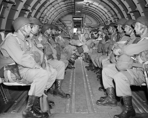 FILE - American paratroopers, heavily armed, sit inside a military plane as they soar over the English Channel en route to the Normandy French coast for the Allied D-Day invasion of the German stronghold during World War II, June 6, 1944. Nearly 160,000 Allied troops landed in Normandy on June 6, 1944. Of those, 73,000 were from the United States, 83,000 from Britain and Canada. Forces from several other countries were also involved, including French troops fighting with Gen. Charles de Gaulle. The Allies faced around 50,000 German forces. (AP Photo, File)