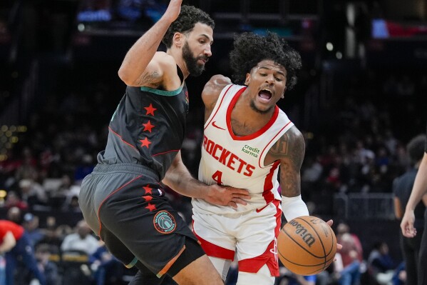 Washington Wizards forward Anthony Gill, left, fouls Houston Rockets guard Jalen Green during the first half of an NBA basketball game Tuesday, March 19, 2024, in Washington. (AP Photo/Alex Brandon)