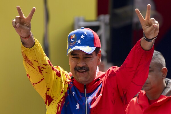 FILE - President Nicolas Maduro flashes victory signs during an event commemorating a 2004 speech by the late President Hugo Chavez, that is considered a key anti-imperialist moment by his supporters in the history of his Bolivarian Revolution, in Caracas, Venezuela, Feb 29, 2024. Maduro is the only candidate with a guaranteed spot on the ballot in Venezuela’s upcoming presidential election. (AP Photo/Ariana Cubillos, File)