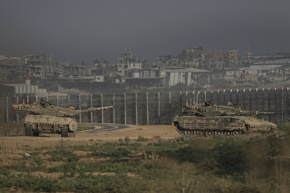 Israeli tanks stand near the Israel-Gaza border as seen from southern Israel Sunday, July 14, 2024. (AP Photo/Tsafrir Abayov)