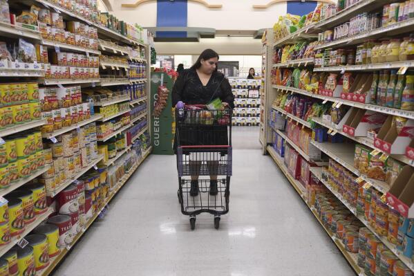 Jaqueline Benitez pushes her cart down an aisle as she shops for groceries at a supermarket in Bellflower, Calif., on Monday, Feb. 13, 2023. Benitez, 21, who works as a preschool teacher, depends on California's SNAP benefits to help pay for food, and starting in March she expects a significant cut, perhaps half, of the $250 in food benefits she has received since 2020. (AP Photo/Allison Dinner)