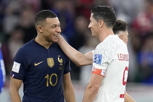 FILE - France's Kylian Mbappe, left, and Poland's Robert Lewandowski, right, speak after the World Cup round of 16 soccer match between France and Poland, at the Al Thumama Stadium in Doha, Qatar, Sunday, Dec. 4, 2022. Mbappe leads France in Euro 2024 group against teams he loves scoring against. (AP Photo/Natacha Pisarenko, File)