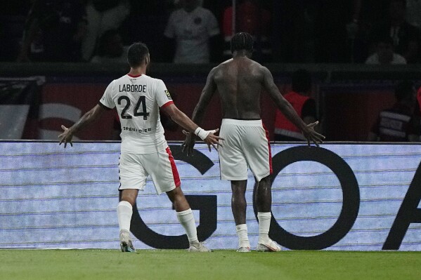Nice's Terem Moffi, right, celebrates with his teammate Gaetan Laborde after scoring his side's third goal during the French League One soccer match between Paris Saint Germain and Nice at Parc des Princes stadium in Paris, Friday, Sept. 15, 2023. (AP Photo/Michel Euler)