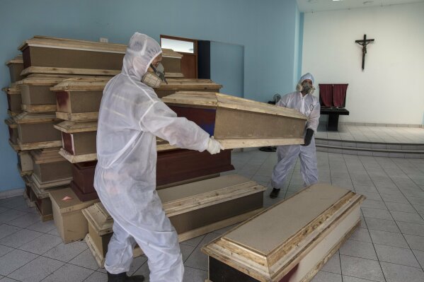 Funeral home workers prepare to load coffins into a waiting vehicle to transport to a public hospital in order to pick up bodies of deceased persons who are suspected to have died from the new coronavirus, at a crematorium in Lima, Peru, Wednesday, May 20, 2020. (AP Photo/Rodrigo Abd)