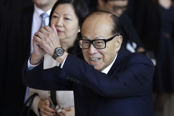 Hong Kong tycoon Li Ka-shing, chairman of CK Hutchison Holdings company, waves to media after the company's Annual General Meeting in Hong Kong, May 10, 2018. (AP Photo/Kin Cheung, File)