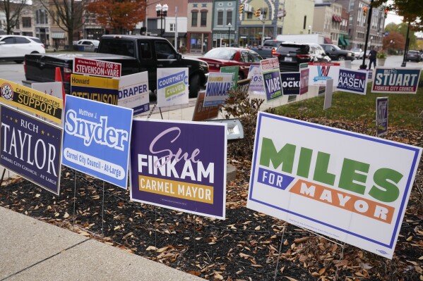 Signs for the Carmel, Ind. mayoral race between Democrat Miles Nelson and Republican Sue Finkam are among the display for signs outside an early voting site at the Hamilton County Courthouse in Noblesville, Ind., Thursday, Oct. 26, 2023. (AP Photo/Michael Conroy)