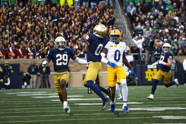 Notre Dame safety Xavier Watts (0) intercepts a pass intended for Pittsburgh wide receiver Bub Means (0) as Notre Dame cornerback Christian Gray (29) watches during the first half of an NCAA college football game Saturday, Oct. 28, 2023, in South Bend, Ind. (AP Photo/Michael Caterina)