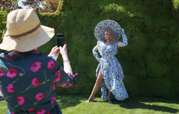 A visitor photographs Tom Leonard the Drag Queen Gardener at the Chelsea Flower Show in London, Monday, May 20, 2024. (AP Photo/Kirsty Wigglesworth)