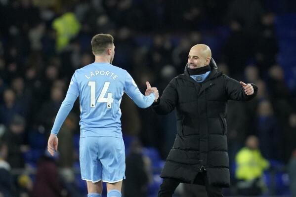 Manchester City's head coach Pep Guardiola, right, celebrates with Manchester City's Aymeric Laporte at the end of the English Premier League soccer match between Everton and Manchester City at Goodison Park in Liverpool, England, Saturday, Feb. 26, 2022. (AP Photo/Jon Super)