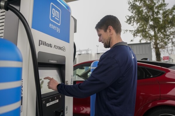 Liam Sawyer, of Indianapolis, touches the screen as he charges his 2023 Ford Mustang Mach-E, Friday, March 8, 2024, at an electrical automobile charging station in London, Ohio. The charging ports are a crucial part of President Joe Biden's effort to motivate chauffeurs to move far from gasoline-powered cars and trucks and trucks that add to international warming. (AP Photo/Joshua A. Bickel)