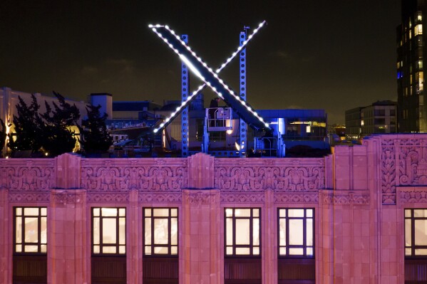FILE - Workers install lighting on an "X" sign atop the company headquarters, formerly known as Twitter, in downtown San Francisco, July 28, 2023. (AP Photo/Noah Berger, File)