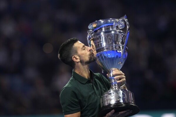 Serbia's Novak Djokovic kisses the trophy as ATP world best player at the ATP World Tour Finals, at the Pala Alpitour, in Turin, Italy, Monday, Nov. 13, 2023. Djokovic was presented with the trophy for finishing the year ranked No. 1. (AP Photo/Antonio Calanni)