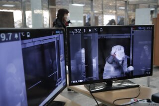 A thermal camera monitor shows the body temperature of a visitor arriving at the ISU Four Continents Figure Skating Championships in Seoul, South Korea, Thursday, Feb. 6, 2020. Ten more people were sickened with a new virus aboard one of two quarantined cruise ships with some 5,400 passengers and crew aboard, health officials in Japan said Thursday, as China reported 73 more deaths and announced that the first group of patients were expected to start taking a new antiviral drug. (AP Photo/Lee Jin-man)