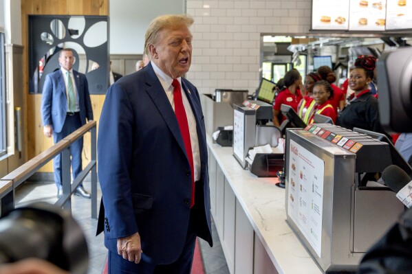 ARCHIVO - El expresidente y candidato republicano a la presidencia, Donald Trump, centro, visita un restaurante de la cadena Chick-fil-A en Atlanta, el 10 de abril de 2024. (AP Foto/Jason Allen, archivo)