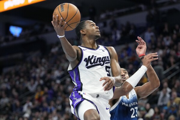 Sacramento Kings guard De'Aaron Fox (5) goes up to shoot as Minnesota Timberwolves forward Troy Brown Jr. (23) follows during the second half of an NBA basketball In-Season Tournament game, Friday, Nov. 24, 2023, in Minneapolis. (AP Photo/Abbie Parr)