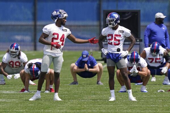 New York Giants cornerbacks James Bradberry (24) and Rodarius Williams (25) chat as other players stretch during an NFL football practice, Thursday, June 10, 2021, in East Rutherford, N.J. (AP Photo/Kathy Willens)