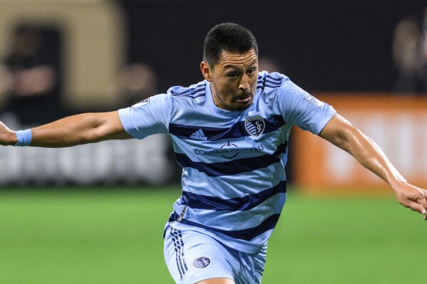  FILE - Sporting Kansas City midfielder Roger Espinoza (15) during the second half of an MLS soccer match against Atlanta United, Sunday, Feb. 27, 2022, in Atlanta. Espinoza, whose last game with Kansas City was in the Western Conference semifinals last November, announced his retirement on Wednesday, June 26, 2024. (AP Photo/Danny Karnik, File)