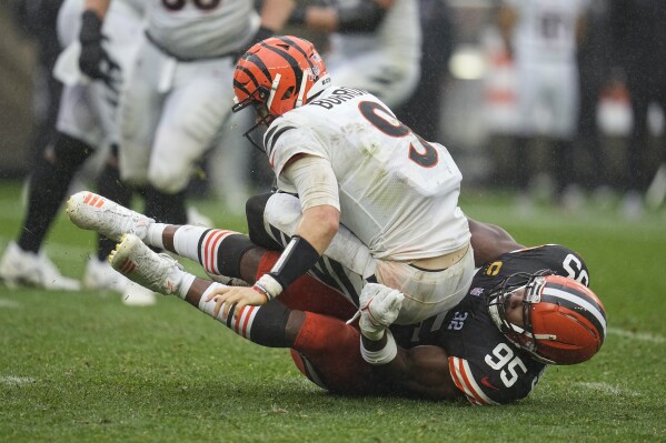 Cincinnati Bengals quarterback Joe Burrow (9) is sacked by Cleveland Browns defensive end Myles Garrett (95) during the second half of an NFL football game Sunday, Sept. 10, 2023, in Cleveland. (AP Photo/Sue Ogrocki)