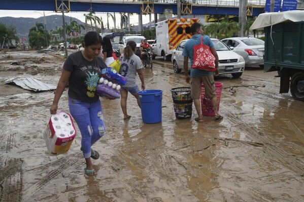 People carry away toilet paper, eggs and cereal from a grocery store after Hurricane Otis ripped through Acapulco, Mexico, Wednesday, Oct. 25, 2023. Hurricane Otis ripped through Mexico's southern Pacific coast as a powerful Category 5 storm, unleashing massive flooding, ravaging roads and leaving large swaths of the southwestern state of Guerrero without power or cellphone service. (AP Photo/Marco Ugarte)