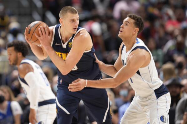 Denver Nuggets center Nikola Jokic, left, looks to pass the ball as Dallas Mavericks center Dwight Powell defends in the first half of an NBA basketball game Friday, Oct. 29, 2021, in Denver. (AP Photo/David Zalubowski)