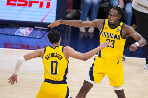 Indiana Pacers forward Aaron Nesmith (23) celebrates after a basket with Indiana Pacers guard Tyrese Haliburton (0) during overtime in Game 2 in an NBA basketball first-round playoff series, Friday, April 26, 2024, in Indianapolis. (AP Photo/Michael Conroy)