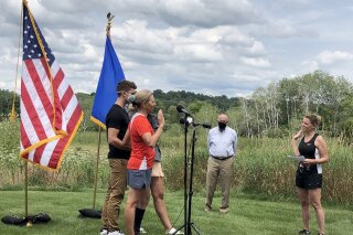 Wisconsin Supreme Court Justice Jill Karofsky is sworn in by fellow Justice Rebecca Dallet, right, as her children, Danny and Daphne, and former Gov. Jim Doyle look on. Karofsky took the oath Saturday, Aug. 1, 2020, in Basco, Wis., during a break in a 100-mile run. (Patrick Marley/Milwaukee Journal-Sentinel via AP)