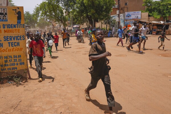 FILE - Children run in the streets of Niamey, Niger, on Aug. 13, 2023. Defense chiefs from the West African regional bloc, ECOWAS, are meeting in Ghana Thursday Aug. 17, 2023 to discuss Niger's crisis after a deadline passed for mutinous soldiers to release and reinstate President Mohamed Bazoum or face military intervention. (AP Photo/Sam Mednick, File)