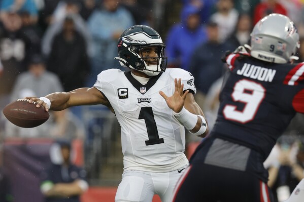 Philadelphia Eagles quarterback Jalen Hurts (1) looks for an opening while under pressure from New England Patriots linebacker Matthew Judon (9) in the first half of an NFL football game, Sunday, Sept. 10, 2023, in Foxborough, Mass. (AP Photo/Michael Dwyer)
