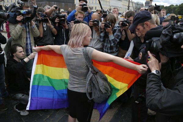 FILE - A gay rights activist stands with a rainbow flag, in front of journalists, during a protesting picket at Dvortsovaya (Palace) Square in St.Petersburg, Russia, Sunday, Aug. 2, 2015. Russia鈥檚 Supreme Court on Thursday, Nov. 30, 2023, effectively outlawed LGBTQ+ activism, in the most drastic step against advocates of gay, lesbian and transgender rights in the increasingly conservative country. (AP Photo, File)