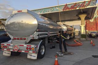 In this May 20, 2021 photo, a fuel truck driver checks the gasoline tank level at a United Oil gas station in Sunset Blvd., in Los Angeles. The average U.S. price of regular-grade gasoline jumped 8 cents over the past two weeks, to $3.10 per gallon. Industry analyst Trilby Lundberg of the Lundberg Survey said Sunday, May 23, 2021 that the increase is attributed to supply disruption from the 10-day shutdown of the Colonial Pipeline following a cyberattack, and a rise in prices for corn, a key ingredient in corn-based ethanol that must be blended by refiners into gasoline. (AP Photo/Damian Dovarganes)