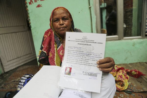 Krishna Singh shows her domicile certificate in Jammu, India, July 27, 2020. A year after India ended disputed Kashmir's semi-autonomous status and downgraded it to a federally governed territory, ...