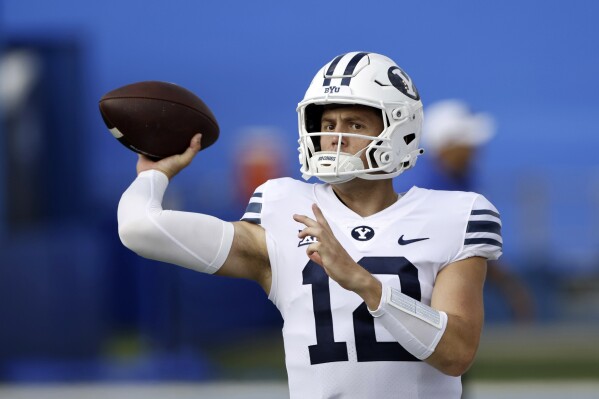 FILE - BYU quarterback Jake Retzlaff (12) passes during an NCAA college football game Saturday, Sept. 23, 2023, in Lawrence, Kan. BYU has to replace Kedon Slovis after his only season at his third school. The Cougars quarterback competition will go into fall camp between South Florida transfer Gerry Bohanon, who before that was Baylor's starter for its Big 12 championship game win in 2021, and Jake Retzlaff, their backup last season. (AP Photo/Colin E. Braley, File)
