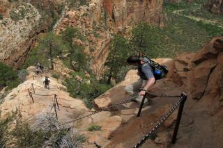 FILE - In this May 8, 2011, file photo, hikers climb down the Angels Landing trail in Zion National Park in Utah. A permit is now required to hike Angels Landing at Zion National Park. KUER reports that some of the first people to hike it with the new system in place said it was less crowded and felt safer. Park visitor use manager Susan McPartland said the reduced crowding and enhanced safety is exactly why the new pilot program was put into place. (Jud Burkett/The Spectrum via AP, File)