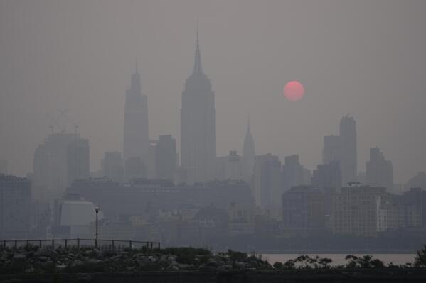The sun rises over a hazy New York City skyline as seen from Jersey City, N.J., Wednesday, June 7, 2023. (AP Photo/Seth Wenig)